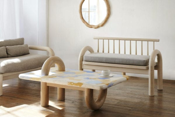 Adding a little whimsy to a room, this bench is understated but unique. The shape of the arms is playful, mixed with a more traditional spindle style back.